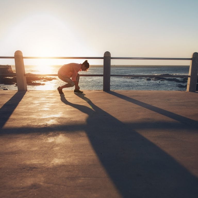 Fit woman tying her laces before a run.